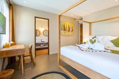 a bedroom with a bed and a desk and a table at Garbera 2 BR Private Pool Villa in Canggu