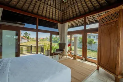 a bedroom with a bed and large glass windows at Ocean Breeze Villa -4BR villa in Canggu in Canggu