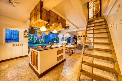 a kitchen with a staircase leading up to a dining room at New Listing 1 BD Vintage Charm in Central Berawa in Canggu