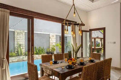 a dining room with a table and chairs and a pool at Comfy 3bd Family Villa with Private Pool in Central Location in Kerobokan