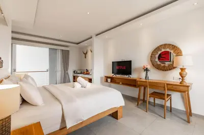 a bedroom with a bed and a desk and a television at Stylish 1 Bd Pvt Apartment w shared kitchen and pool in Seminyak