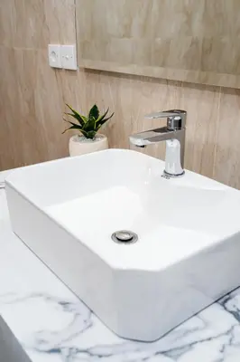 a white sink in a bathroom with a potted plant at Villa Crystal 9b in Seminyak