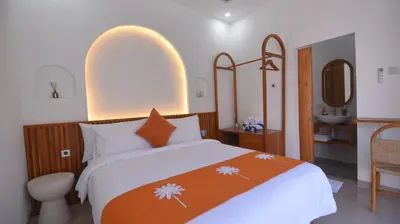 a bedroom with a bed and a bathroom with a sink at Queen Villa Seminyak in Seminyak