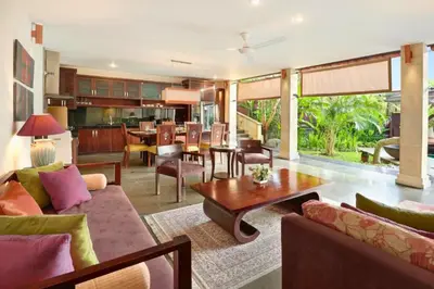 a living room with a couch and a table at Azarina 3 BR Private Pool Villa in Jimbaran