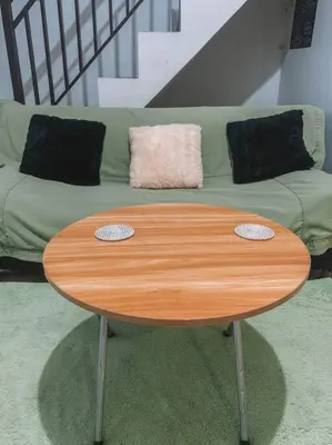 a wooden table in front of a green couch at Conscious House near Kuta and Seminyak in Legian