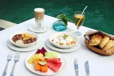 a table with plates of food and glasses of wine at Dendalion 4 BR Private Pool Villa in Jimbaran