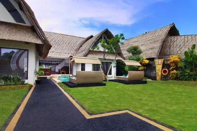 a house with two chairs and a yard at Cozy Executive 2 BR Pool Villa in Seminyak