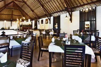 a restaurant with tables and chairs and a pool table at Cozy Executive 2 BR Pool Villa in Seminyak