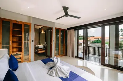 a bedroom with a bed with a ceiling fan at The Golden Serendipity Villa Seminyak in Seminyak