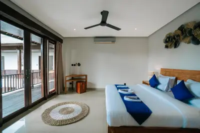 a bedroom with a bed and a balcony at The Golden Serendipity Villa Seminyak in Seminyak