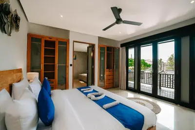 a bedroom with a large bed and a balcony at The Golden Serendipity Villa Seminyak in Seminyak