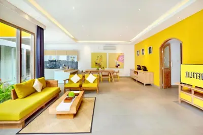 a living room with a yellow couch and a table at Sweet 3 BR Private Pool Villa Garden View in Kerobokan