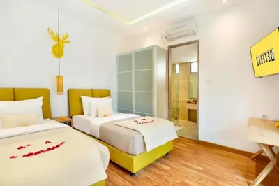 a hotel room with two beds and a desk at Sweet 3 BR Private Pool Villa Garden View in Kerobokan