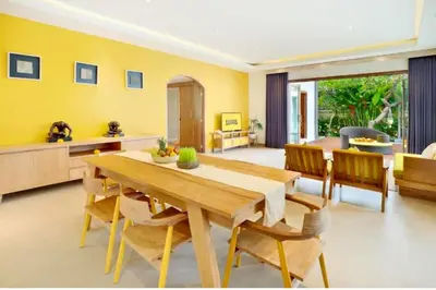 a dining room with a wooden table and chairs at Sweet 3 BR Private Pool Villa Garden View in Kerobokan