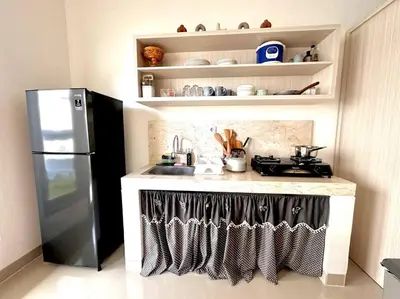 a kitchen with a stove and a refrigerator at Cosy 3 bedrooms at budget price @ Jimbaran in Jimbaran