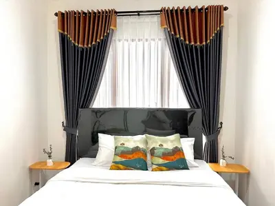 a bedroom with a bed with a window with curtains at Cosy 3 bedrooms at budget price @ Jimbaran in Jimbaran