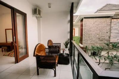a porch with two chairs and a balcony with plants at Taman Bali Villa Kerobokan in Kerobokan