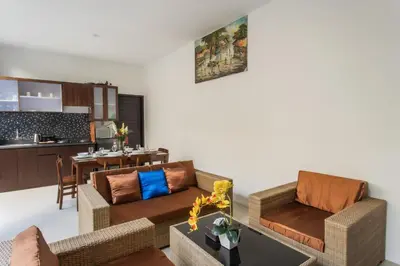 a living room with two couches and a kitchen at Taman Bali Villa Kerobokan in Kerobokan