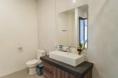 a bathroom with a sink and a toilet and a mirror at Taman Bali Villa Kerobokan in Kerobokan