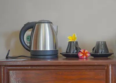 a tea kettle on top of a wooden table at Dirga's House Sanur View by EPS in Sanur