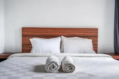 a bedroom with a bed with towels on it at Dukuh Segara Guest House in Legian