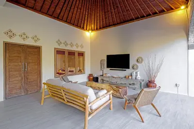 a living room with a couch and chairs and a television at VILLA LA FELICITA in Seminyak