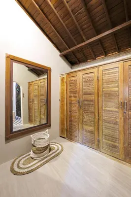 a room with wooden cabinets and a mirror at VILLA LA FELICITA in Seminyak