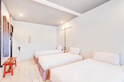 a room with two beds and a cross on the wall at Collection O at Jalan Padma near Legian Beach in Legian