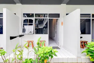 an open door to a white house with plants at Collection O at Jalan Padma near Legian Beach in Legian