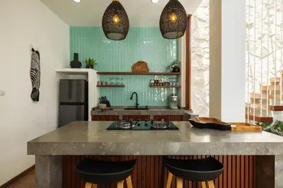 a kitchen with a counter with stools and a sink at Villa Karibu Canggu-2BR with pool & rooftop in Canggu