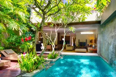 a swimming pool in the middle of a garden at Amani Entire 2 BR Private Pool Villa in Seminyak