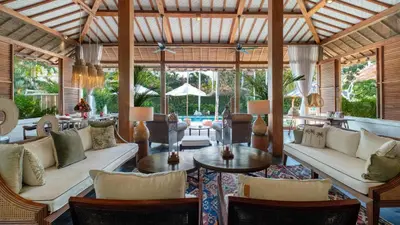 an open living room with white couches and tables at Desa Roro Estate by Villa Finder in Canggu