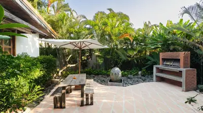 a patio with an umbrella and a grill at Desa Roro Estate by Villa Finder in Canggu