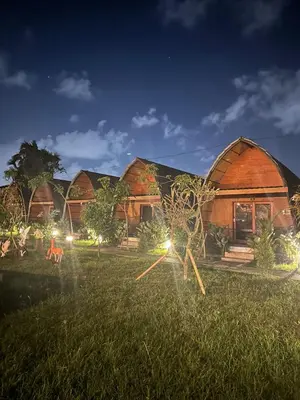 a house with lights in the grass at night at Yogasari Villa Seminyak in Seminyak