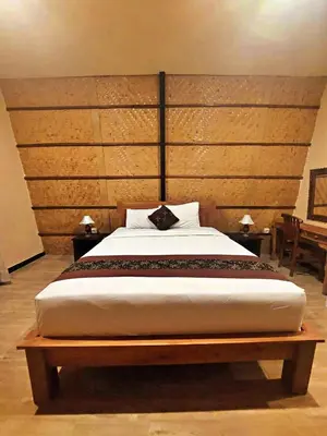 a bedroom with a large bed with a wooden headboard at Yogasari Villa Seminyak in Seminyak