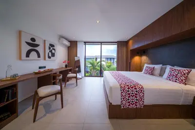 a bedroom with a large bed with a desk and a desk at Umalas Creek Villas in Canggu