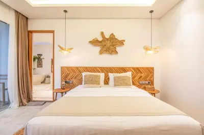 a bedroom with a large bed and a mirror at Brand New 4br Villa 400 to Finns Canggu in Canggu