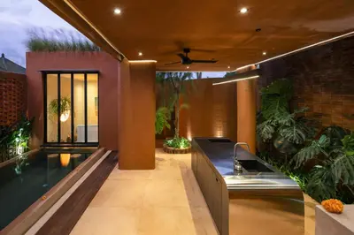 an outdoor kitchen with a sink and a swimming pool at Kula Terra One Bedroom Villa in Kerobokan