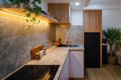 a kitchen with a sink and a black refrigerator at Sunset Suites, 1 bed apartment, Jayakarta hotel in Seminyak