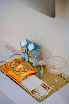 a tray with glasses and a magazine on a table at Sunset Suites, 1 bed apartment, Jayakarta hotel in Seminyak
