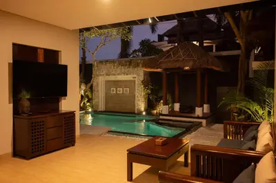 a living room with a swimming pool with a tv at Bali Ula Villa in Nusa Dua