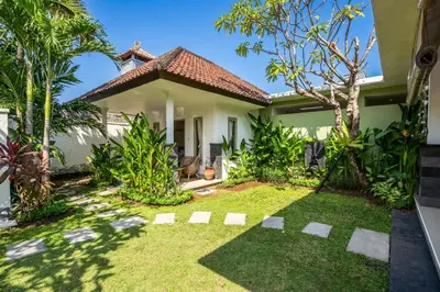 a garden in front of a house at Kupu-Kupu Villa by iBali Management in Canggu
