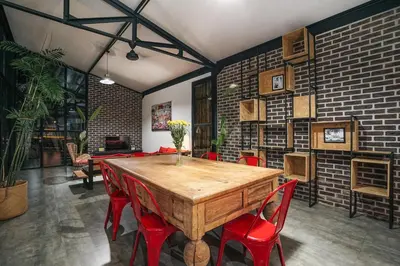 a dining room with a wooden table and red chairs at Villa Costa Plana - 2 bedroom industrial private villa in Umalas, between Canggu & Seminyak in Seminyak