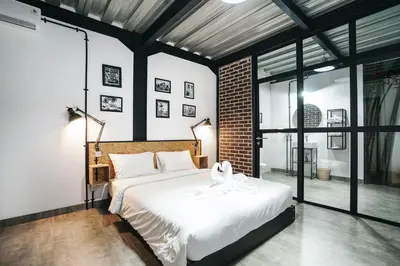 a bedroom with a large bed with white sheets at Villa Costa Plana - 2 bedroom industrial private villa in Umalas, between Canggu & Seminyak in Seminyak