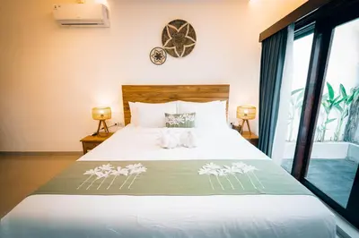 a bedroom with a large bed with flowers on it at Villa Umah Seminyak in Seminyak