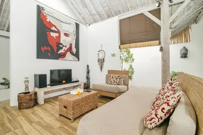 a living room with a bed and a tv at Villa Laksmana 1 in Canggu