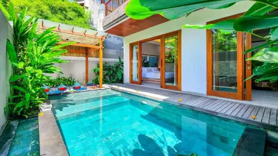 a swimming pool in front of a house at Casa De Gracia Sanur Beach by Nagisa Bali in Sanur
