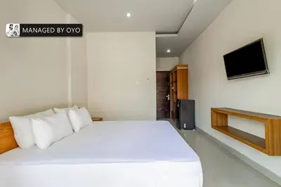 a bedroom with a white bed and a tv at Collection O Near Seminyak Beach Formerly The Kumpi Hotel in Seminyak