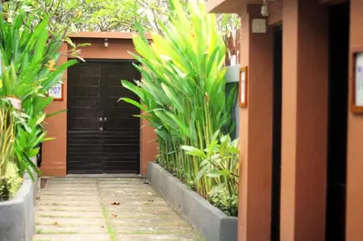 a driveway leading to a black garage with plants at Private Pool Classic Villa in Kuta