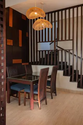 a dining room with a table and chairs and a staircase at Bali Stile villa in Nusa Dua